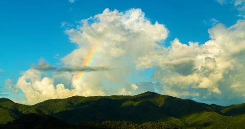 Big clouds and rainbow on sky and mountains Time-lapse . Stock Footage 107959465