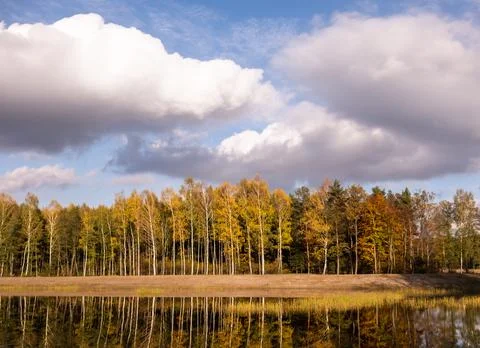 Big clouds on the background of a beautiful forest - autumn lake landscape Stock-Fotos