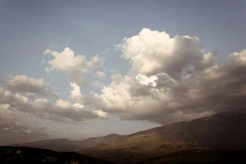 Big clouds on a hilly landscape Stock Photos