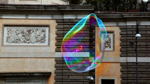 Big colorfull soap bubble flies in the air in Rome, Italy Stock Footage 86544356