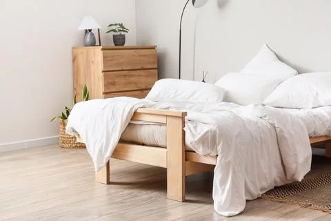 Big comfortable bed with white bedding in hotel room Stock Photos