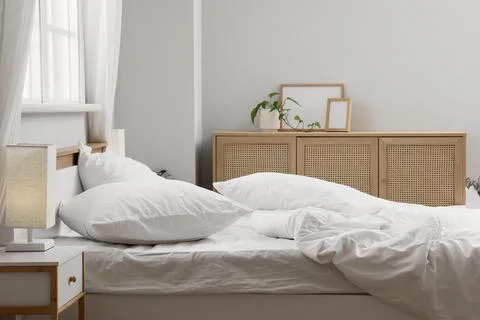 Big comfortable bed with white bedding in hotel room Stock Photos
