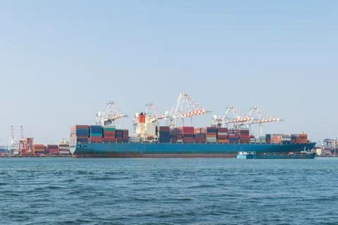 Big container ship and small container ship in asia port while load the job Foto stock