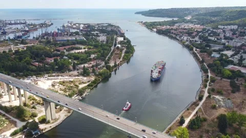 Big container ship moves across the bay under a highway bridge with heavy Stock Footage 211666057