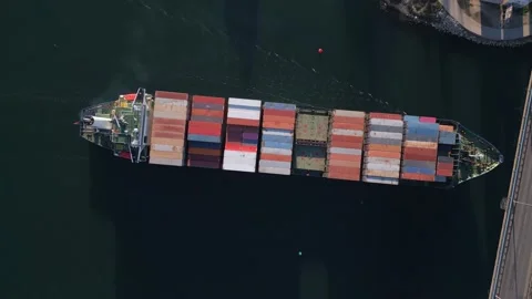 Big container ship moves across the bay under a highway bridge with heavy Video stock 227745743