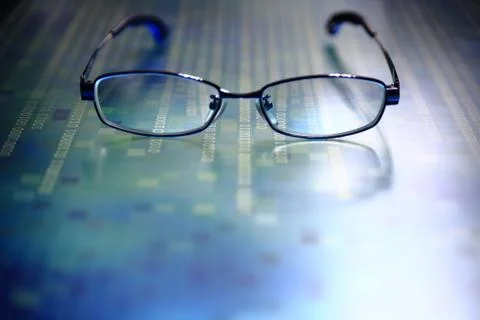 Big data analysis. glasses placed on a LED digital panel display white light Stockfoto's