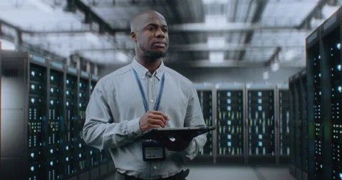 Big Data Center with Server Racks: Specialist Using Tablet Computer, Activating Stock Footage 309314081