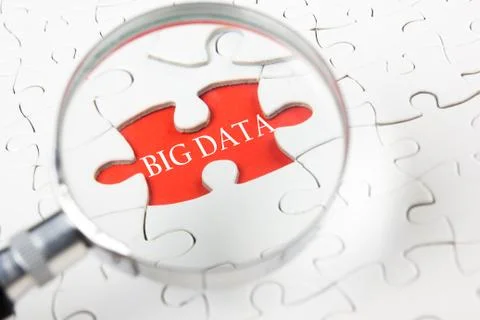 Big Data word with hand holding magnifying glass over jigsaw puzzle 库存照片