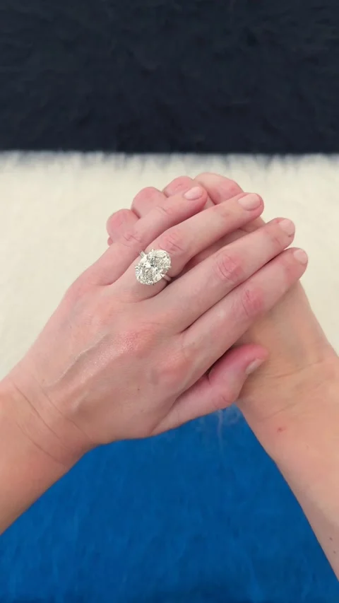 Big diamond oval engagement ring shown from above blue background Video stock 328251205
