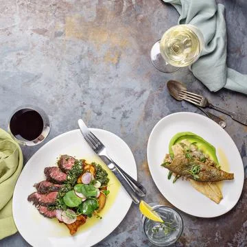 Big dinner table overhead view with steak and fish Stock Photos