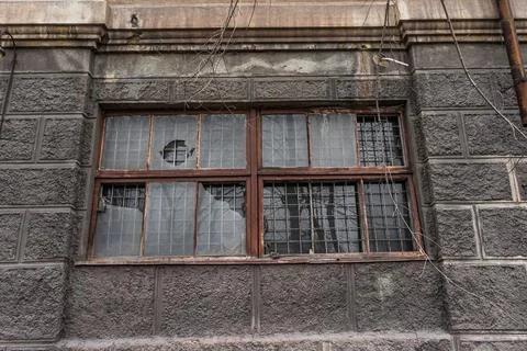 Big dirty broken window. dark wall of a large house. Vintage architecture cla Stock Photos