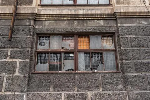 Big dirty broken window. dark wall of a large house. Vintage architecture cla Stock Photos