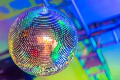 Big disco ball on a colored background in a nightclub Stock Photos
