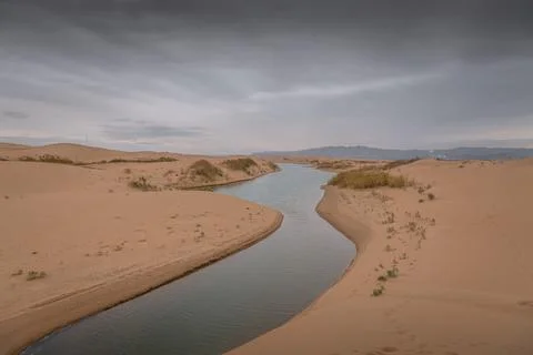 Big dune and the sand texture with the river cutting through at foreground,.. Stock Photos