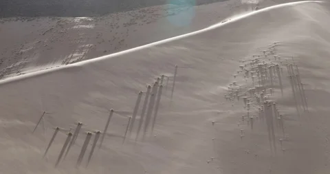 Big dune with wind blowing sand over surface at sunset, flares and volume light 스톡 동영상 103498675