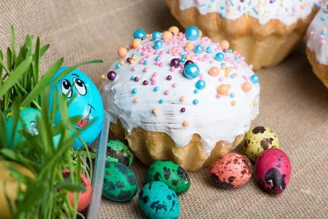 Big Easter cake and colored eggs lie on the background Stock Photos