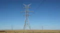 Big electrical pylons in the prairies. Traffic passes below. Alberta, Canada. HD Footage