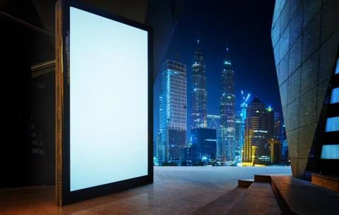 Big empty screen billboard with modern city background . Stock Photos