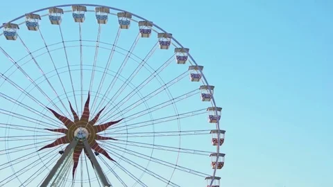 Big Ferris wheel spins clockwise against clear blue sky Stock Footage 83843569