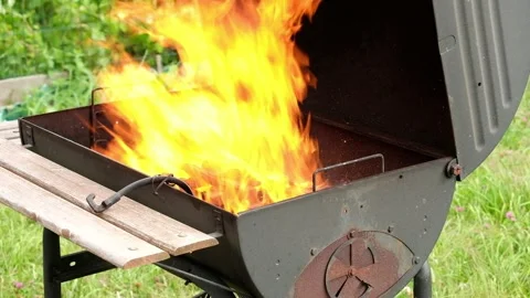 A big fire comes out of a summer outdoor grill. Stock Footage 130668996