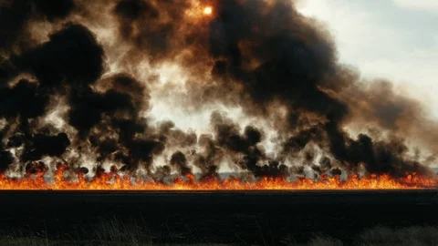Big fire in the field. Thick black smoke overlaps the sun.Scary accident in Stock Footage 105014185