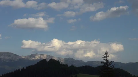 Big fluffy clouds float over mountain's peak, summer day, time lapse Stock Footage 34970572