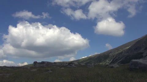 Big fluffy clouds float over mountain's peak, summer day, time lapse Stock Footage 35185708