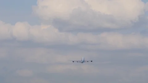 Big four-engine cargo airliner gains height after takeoff and flies to clouds Stockbeeldmateriaal 94514268