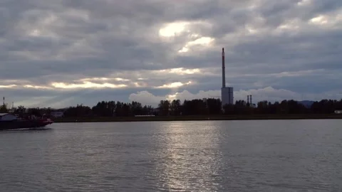 Big freighter ship passing by industrial plant on danube river Stock Footage 147026375