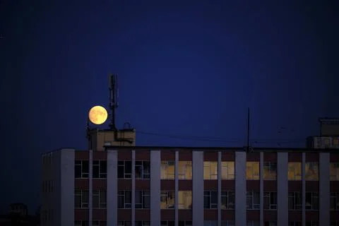 Big full moon over office building in the evening Fotos Stock