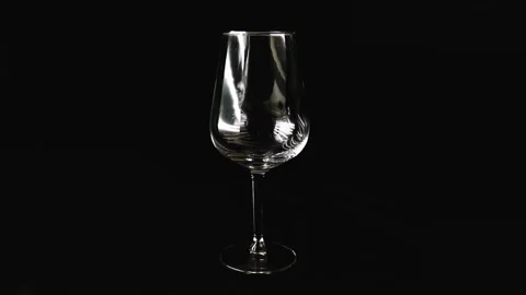 Big glass on a dark background. Red wine is slowly poured into a glass. 스톡 동영상 107781033