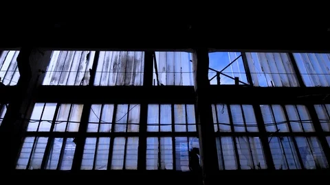 Big glass wall of old empty building with many of windows, camera is moving back Stock Footage 86207017