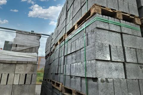 Big gray concrete bricks on pallets on a construction outdoor store Stockfoto's