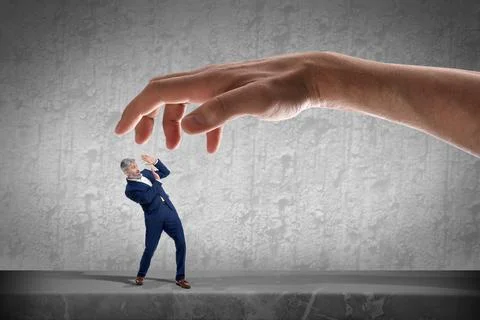 Big hand catching small scared businessman on grey background. Authority, a.. 写真素材