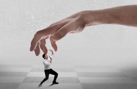 Big hand catching small scared businessman on light background. Authority, .. 写真素材
