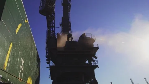 Big harbor crane unloading cargo from bulk carrier with blue sky in background Stock Footage 114509546