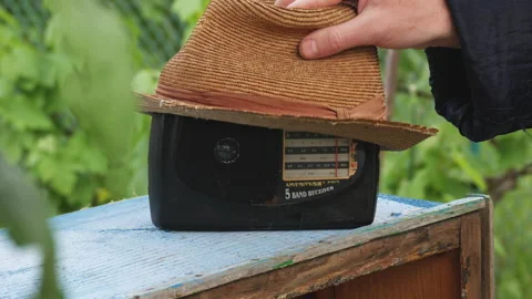 A big hat is put on the old receiver. Vintage radio plays on a sunny summer day Video stock 245075904