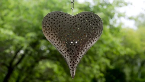 Big heart made of iron with patterns in the form of flowers hanging Stock Footage 76156765