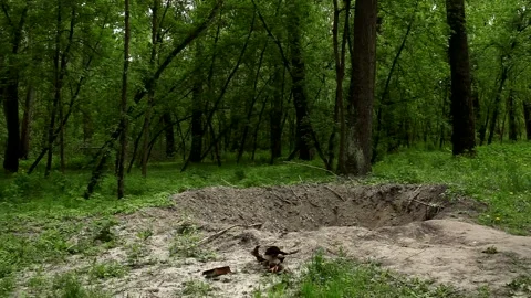 A big hole in the ground after being hit by an artillery shell. Stock Footage 194851880