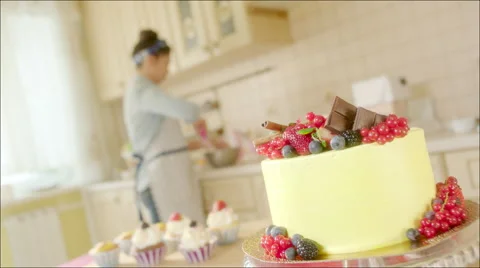 Big home made cake and its cooker in the kitchen Stock Footage 62749380