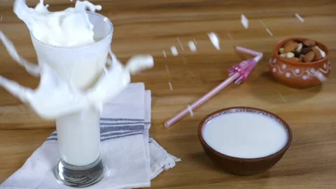 A big ice cube dropped into a transparent glass with refreshing buttermilk Stock Footage 161006603