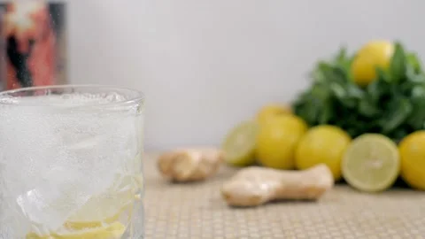 Big ice cubes falling in a glass of fresh soda / tonic water with lemon slices Stock Footage 153070645