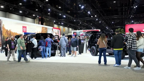 Big indoor auto show, crowds of visitors walking through brightly lit exhibit Stock-Footage 330987203