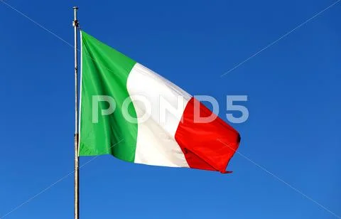 Big Italian flag with the colors red white and green and the blue sky Stock Photos