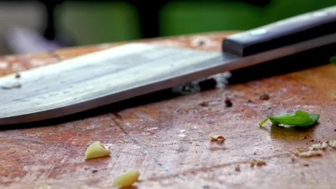 Big kitchen knife lying on an old cutting board Stock Footage 250157868