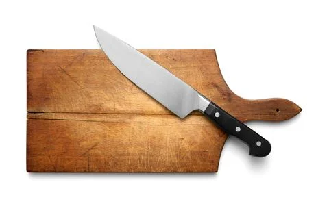 Big kitchen knife lying on an old cutting board Stock Photos