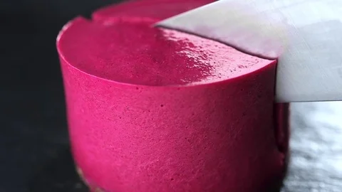 Big knife cuts through the cake with raspberries, the cook cuts tartlet by the Stock Footage 83176810