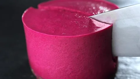 Big knife cuts through the cake with raspberries Stock Footage 143590185