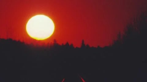 Big low sun ball reflects off railroad tracks Stock Footage 301402604