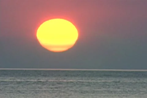 Big low sun ball at sea horizon telephoto Stock Footage 192543238